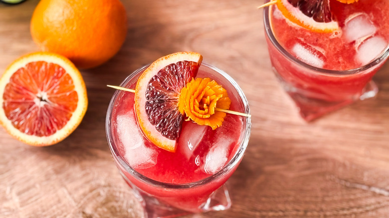 Blood orange crush cocktail with blood orange and orange zest flower garnish
