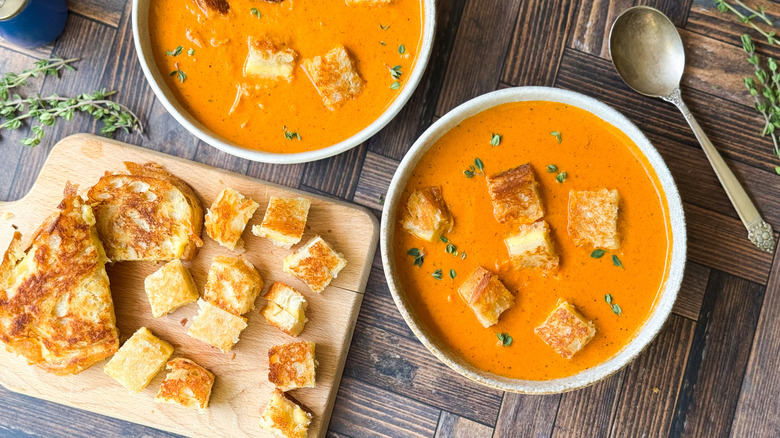 Smoky chicken tomato bisque with grilled cheese croutons in bowls