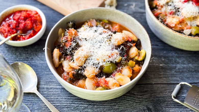 Italian-style butter beans in serving bowl with grated parmesan garnish and Calabrian chilies