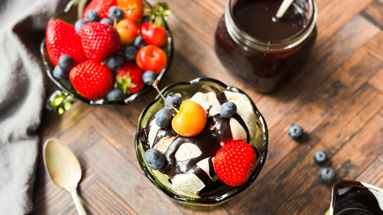 Classic hot fudge sauce over ice cream with berries and cherries