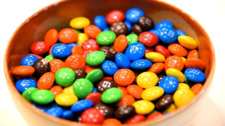 Bowl of classic M&M's in a tan-colored glazed bowl